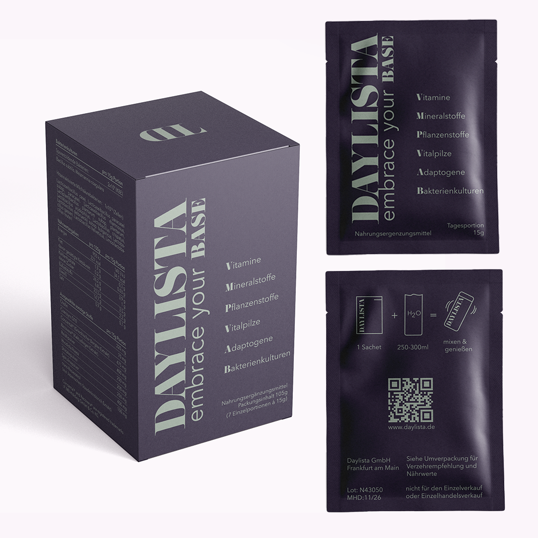 Dunkelviolette Daylista-Box mit der Aufschrift "embrace your base" neben zwei Sachets; auf der Vorderseite der Verpackungen sind die Kategorien Vitamine, Mineralstoffe, Pflanzenstoffe, Vitalpilze, Adaptogene und Bakterienkulturen abgebildet.